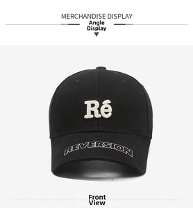 Detail of black cotton cap with white Ré patch embroidery and Reversion brim text