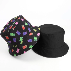 Close-up of reversible bucket hat with colorful gummy bear print and plain black side