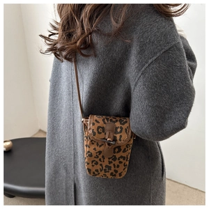 Détail du mini sac léopard avec fermoir toggle sur un manteau en laine grise