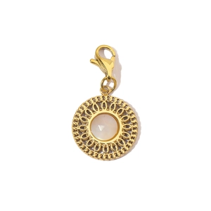 Detailed view of a gold pendant featuring a white gemstone inlay and lobster clasp