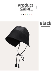 Detail of a black sun hat with long ribbon ties showing silk-like satin fabric texture