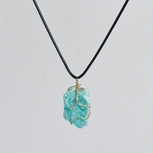 Detail of blue natural crystal stone pendant wrapped in handmade golden wire with cord