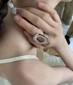 Close-up of minimalist large silver oval statement ring with mirror polish finish