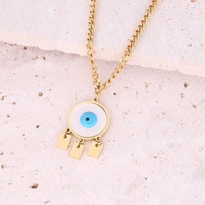 Detailed macro view of golden evil eye necklace with blue enamel and dangling charms