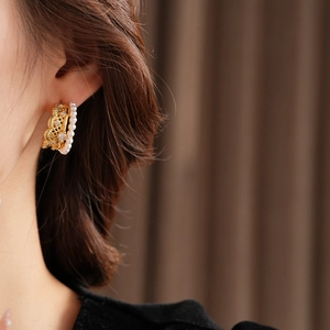 Close-up of pearl hoop earrings with gold mesh lace and sparkling zircon accents