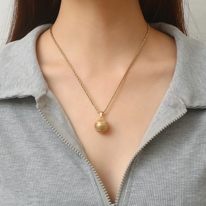 Golden basketball pendant necklace with twisted rope chain displayed on a male model