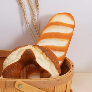 Artificial pretzel and baguette bread models in a woven basket with wheat decor
