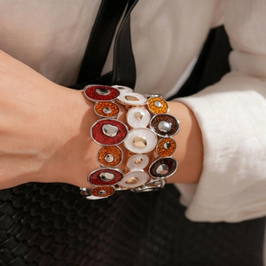 Détail d'un bracelet bohème en émail coloré porté au poignet pour un style de vacances
