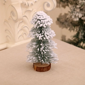 Detail of mini snow-flocked Christmas tree with green needles and natural wood base