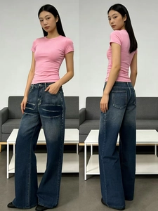 Detail of high-waist wide-leg denim jeans with retro wash and pink slim-fit t-shirt