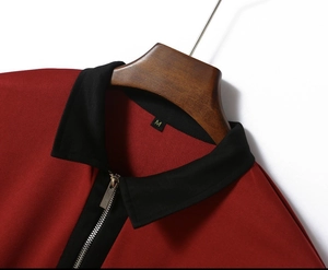 Detail of red polo shirt collar with black zipper placket and textured waffle knit fabric