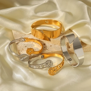 Detail of mixed-metal star pattern bangles on silk fabric and stone display