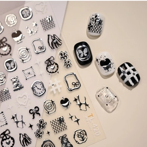 Detail of silver embossed nail stickers with butterfly and star motifs on manicured nails
