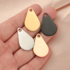 Polished stainless steel teardrop pendants in gold, silver and black on pink silk