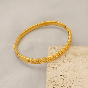 Macro detail of gold-plated titanium steel bracelet featuring a half-chain industrial design