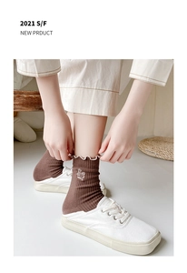 Detail of brown ribbed cotton socks with white lettuce trim and floral embroidery