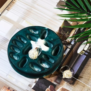 Detailed close-up of white rose open rings on a stylish green stone display stand