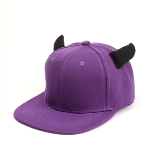 Detail of purple flat brim cap with black 3D devil horns made of high-quality twill cotton