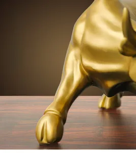 Close-up of golden bull statue showing muscular legs and detailed resin craftsmanship