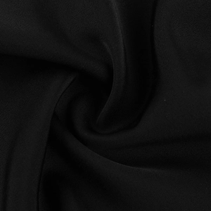 Close-up of the smooth black textile fabric texture with elegant draped folds