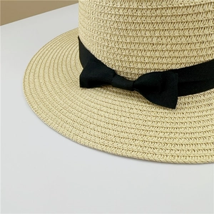 Détail d'un chapeau en paille tissé main avec texture fine et ruban gros-grain noir