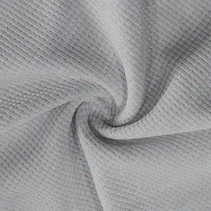 Macro shot of grey waffle knit fabric texture showing breathable weave and soft drape