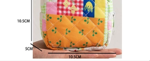 Detailed size view of quilted floral sanitary bag held in hand showing 10.5cm by 5cm dimensions