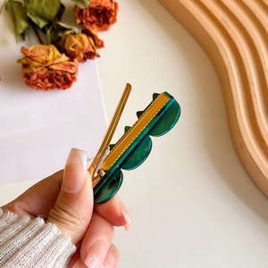 Elegant cat-shaped green acetate hair clip with gold metal base for women styling