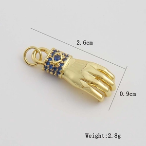 Détail du pendentif poing doré avec zircons bleus et dimensions de 2,6x0,9 cm