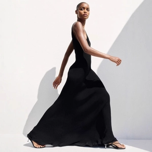 Detail of elegant black knitted maxi dress with backless cut and ribbed texture