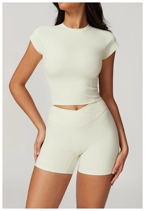 Detail of cream yoga set showing high-waisted shorts with a unique V-shaped cross design