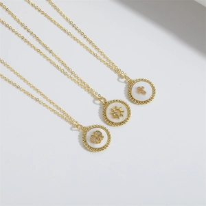 Detailed macro view of gold-plated necklaces with butterfly sun and cross shell pendants