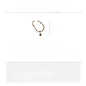 Detail of two-layer brass necklace with tiger eye stone beads and crystal pendants