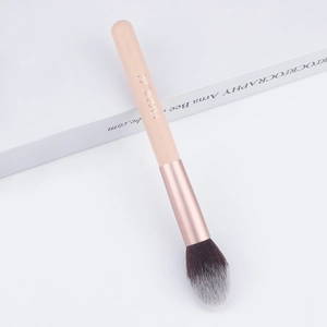 Detail of soft gradient synthetic bristles and rose gold ferrule on makeup brush