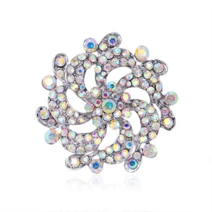 Macro shot of silver-tone spiral brooch with iridescent rhinestones and pearls