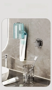 Detail of wall-mounted toothbrush holder with thick blue and grey transparent plastic cups