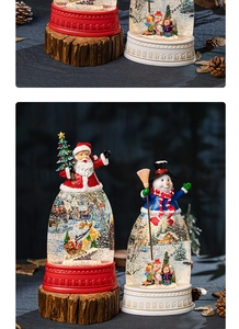 Detail of Christmas snow globe featuring Santa and snowman motifs with wood-style base