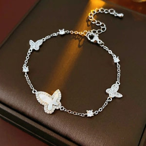 Macro shot of silver butterfly bracelet with white mother of pearl and zircon details