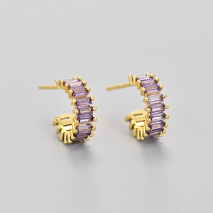 Detail view of gold hoop earrings set with shimmering purple rectangular zircon stones