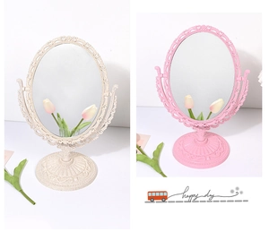 Detail of vintage embossed desktop makeup mirrors in cream white and pink color options