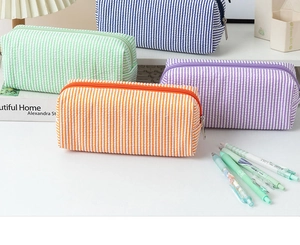 Detailed view of colorful seersucker pencil cases in orange, green, blue, and purple tones