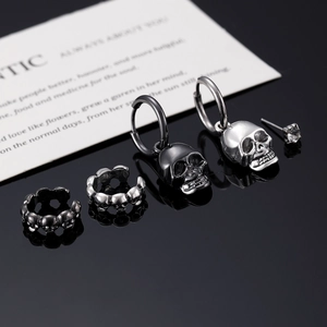 Detailed view of punk skull earring set featuring black and silver gothic jewelry pieces