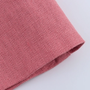 Close-up of pink linen fabric texture showing cross-weave detail on a vest suit set