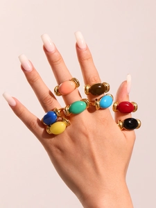 Detail of colorful resin rings in 18K gold plated stainless steel on a hand