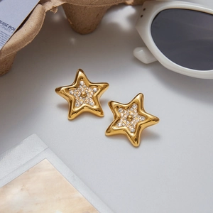 Gros plan de boucles d'oreilles étoiles dorées avec strass dans un décor style ins