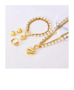 Flat lay of gold heart jewelry set including pearl necklace, bracelet, earrings and ring