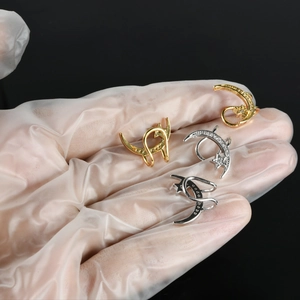 Detail of star and moon ear cuffs in gold and silver with inlaid sparkling zircons