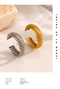 Detailed view of textured gold and silver pleated rings on a natural stone base