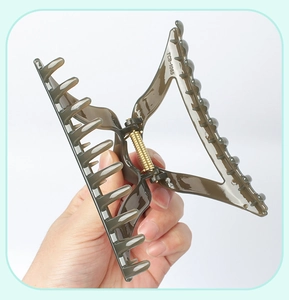 Detail of deep green transparent triangle hair claw clip with strong metal spring mechanism