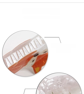Vue détaillée des pinces à cheveux renard orange et blanc perle avec une finition polie lisse